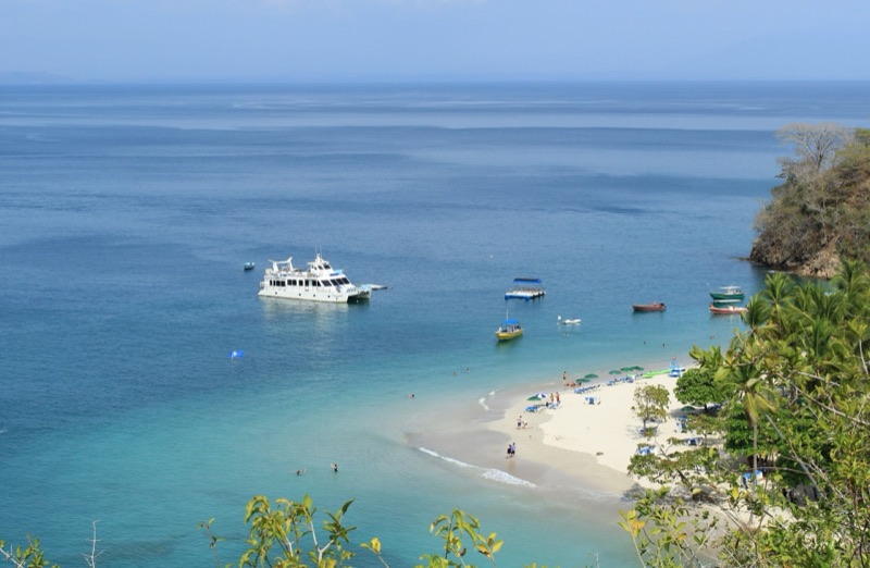 Boats anchored off the white-sand beach at Isla Tortuga, seen from above
